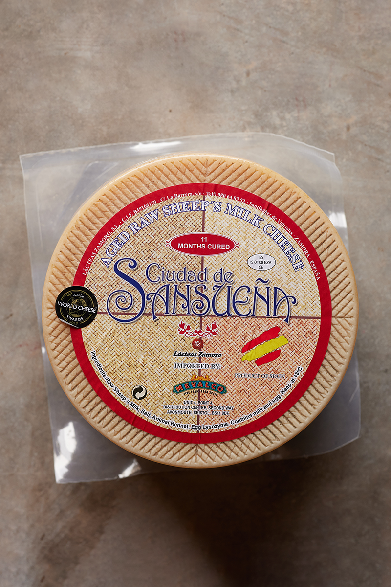 Round cheese with a red and beige label 