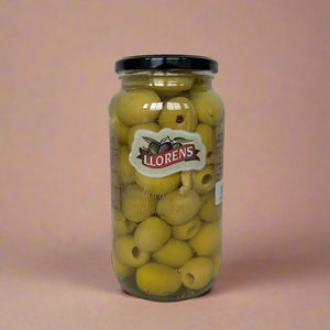 Jar of Llorens olives on a textured surface with a light background